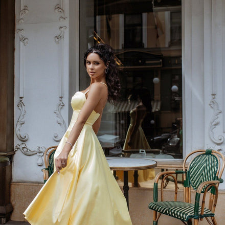 Rosine satin dress in yellow at a café table